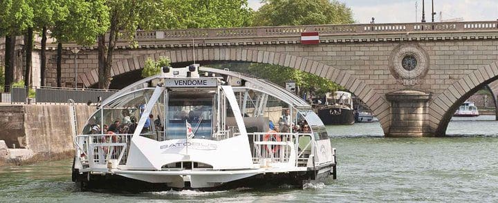 A boat moves down the Seine River on a Paris Private Day Tour & Seine Cruise for Kids and Families .