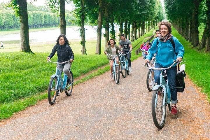 Tourists enjoy a bike ride through Versailles, while on the Versailles Bike Tour With Palace Timed Entry Ticket & Marie Antoinette’s Domain.