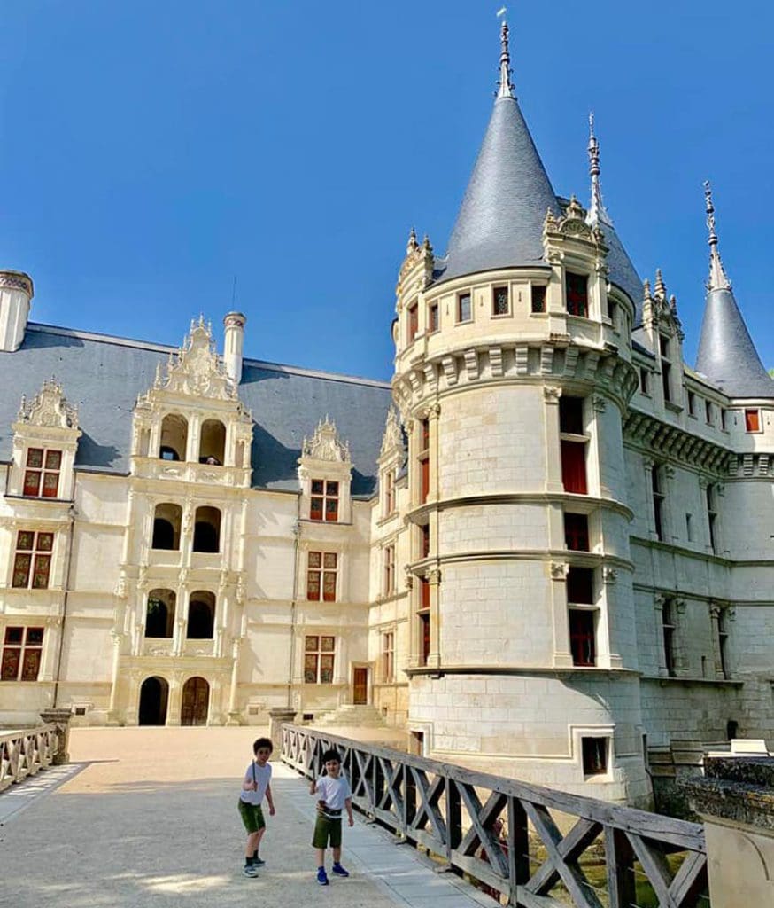 Two kids play outside of a chateau in the Loire Valley.