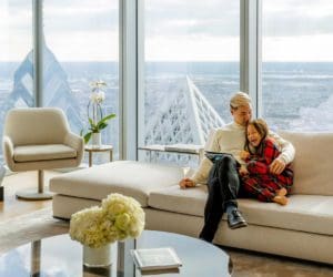 A father and his daughter sit together on a couch, while staying at the Four Seasons Hotel Philadelphia.