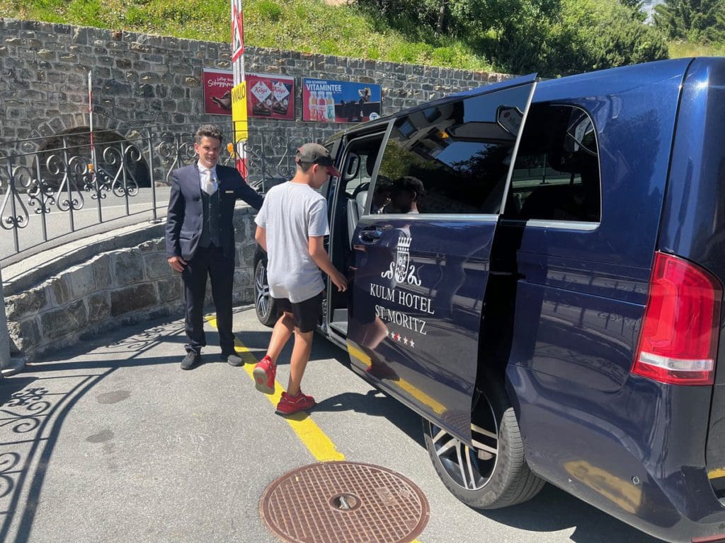 A young boy enters a car service provided by the hotel, one of the things you'll learn about in this review of Kulm Hotel St. Moritz.