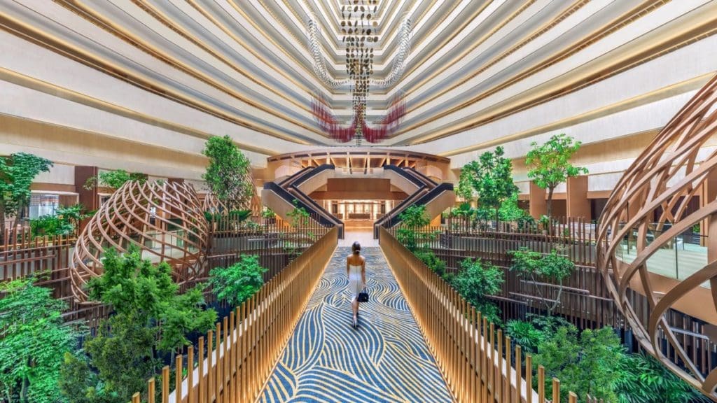 A woman walks across the skybridge in PARKROYAL COLLECTION Marina Bay.