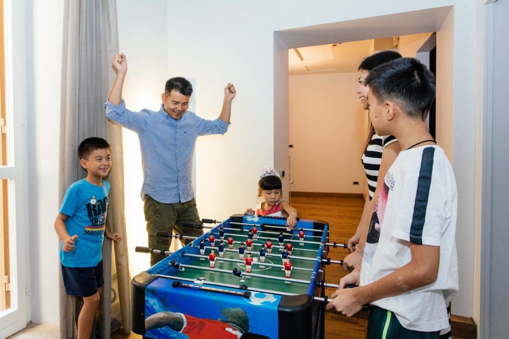 A family plays foosball while staying at Palazzo Scanderbeg.