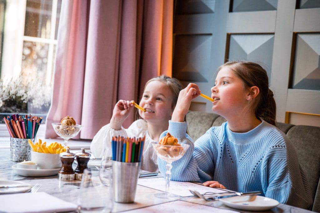 Two young girls eat breakfast, while staying at Pulitzer Amsterdam.
