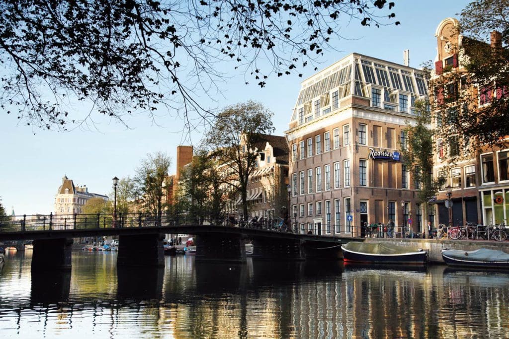 The exterior of Radisson Blu Hotel, Amsterdam City Center along a canal.