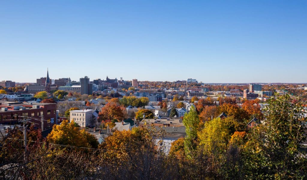 An aerial view of Portland, Maine, with vibrant fall foliage throughout the city, one of the best places to visit for fall in New England with kids.