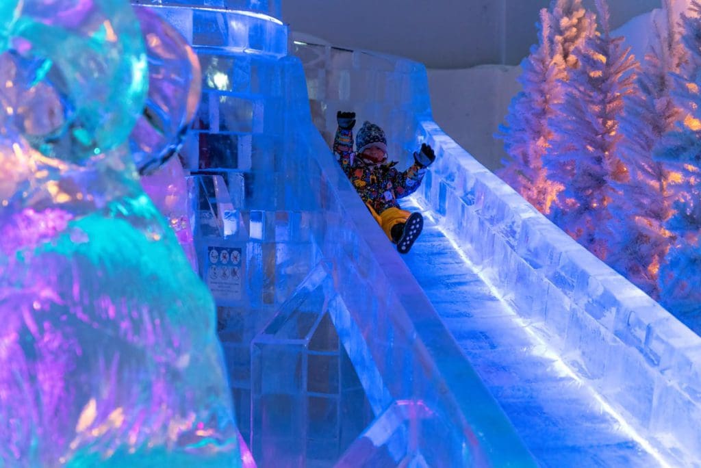 Kids sled down an ice slide at Seaside Glass Villas.