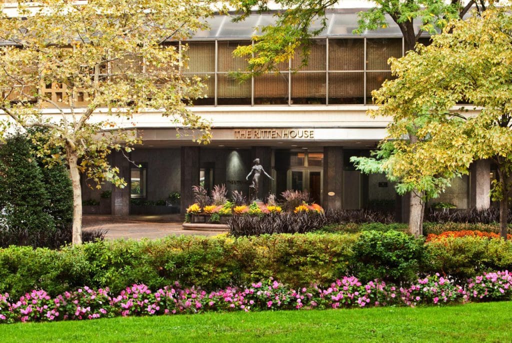 The entrance to The Rittenhouse Hotel, nestled amongst a lush garden.