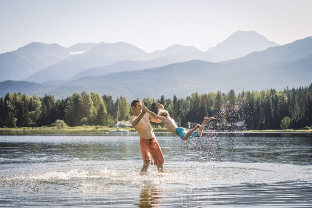 A dad and his young son play together in the lake at Lakeside Park.