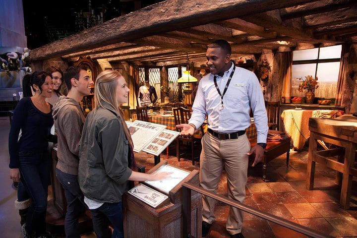 A tour guides gives information to a small group on a guided Warner Bros Tour in London, one of the best experiences in London with kids. 