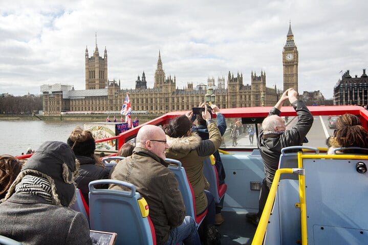 People on a Hop-on, Hop-off bus take pictures as they pass London sites.