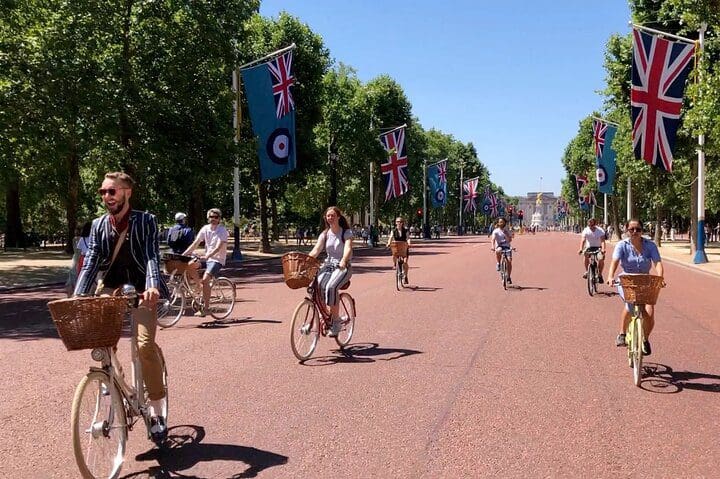 Several people bike along a path, while on a tour of London.