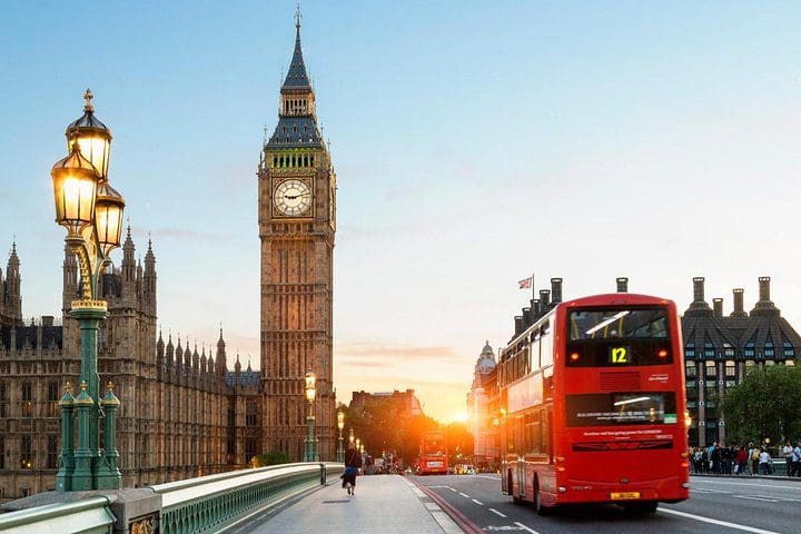 A double decker bus drives by Big Ben in London.