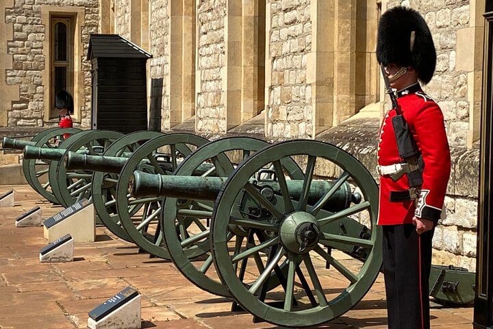 A guard stands near a series of canons in Lonon.
