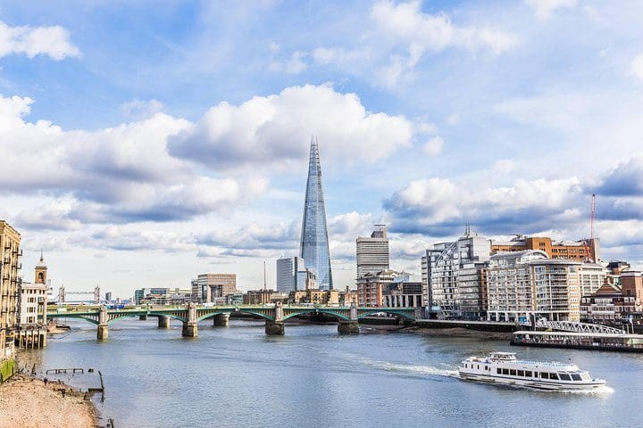 A boat moves down river, while giving people a tour of London by water, one of the best experiences in London with kids. 