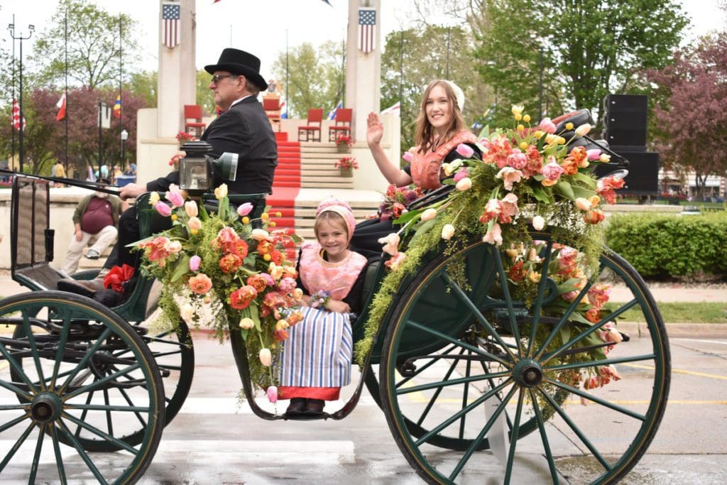 A woman and a young girl are pulled on a carriage during a parade in Pella, Iowa.