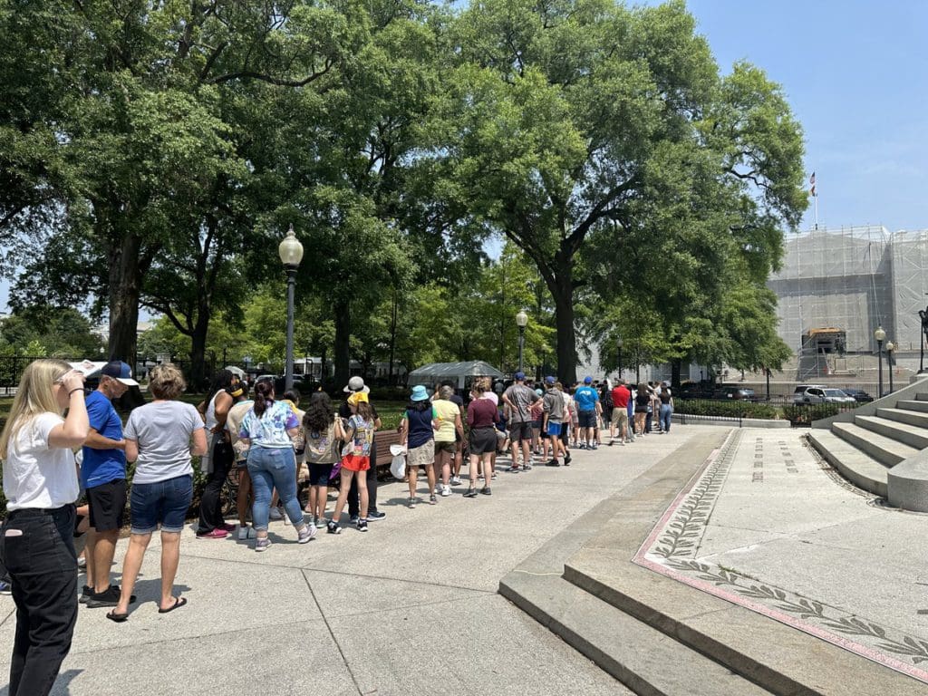 A long line of people awaiting a tour of the White House.