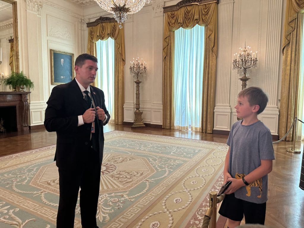 A young boy asks a serviceman a question while on tour.