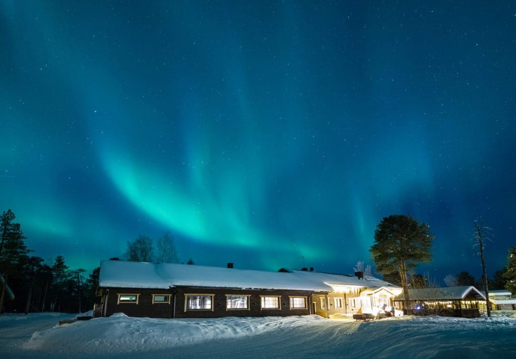 The lodge entrance at Wilderness Hotel Nellim, with the northern lights overhead.