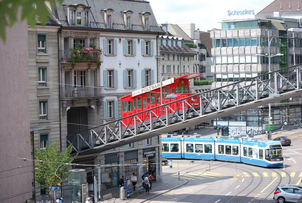 The polybahn moves across its tracks overhead of a street in Zurich.