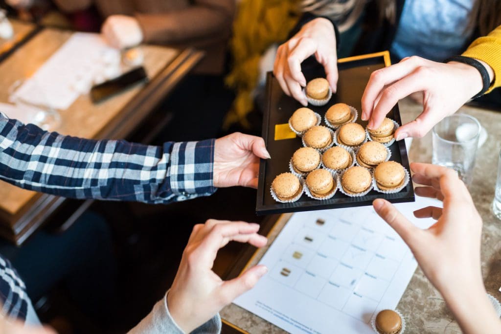 Several hands reach out to try Sprungli, one of Zurich's best desserts.