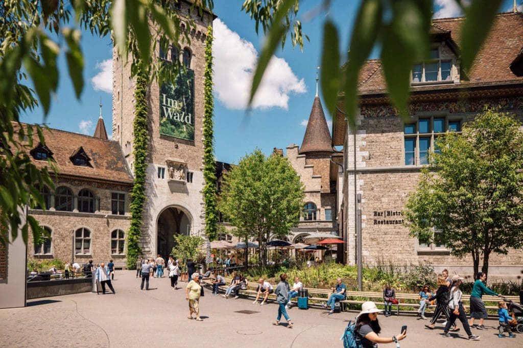 Several people explore the grounds of Landesmuseum, the Swiss National Museum.