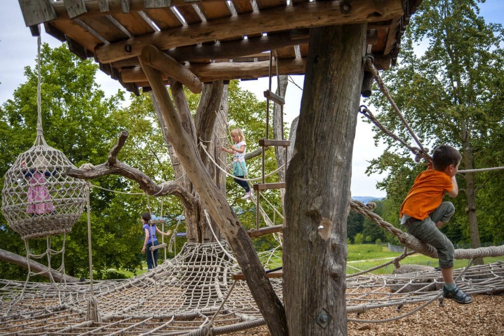 Kids play at a playground, while visiting the Zurich Zoo.