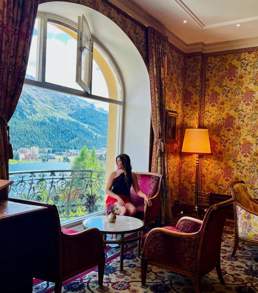 A woman enjoys a scenic mountain view outside the hotel lobby window.