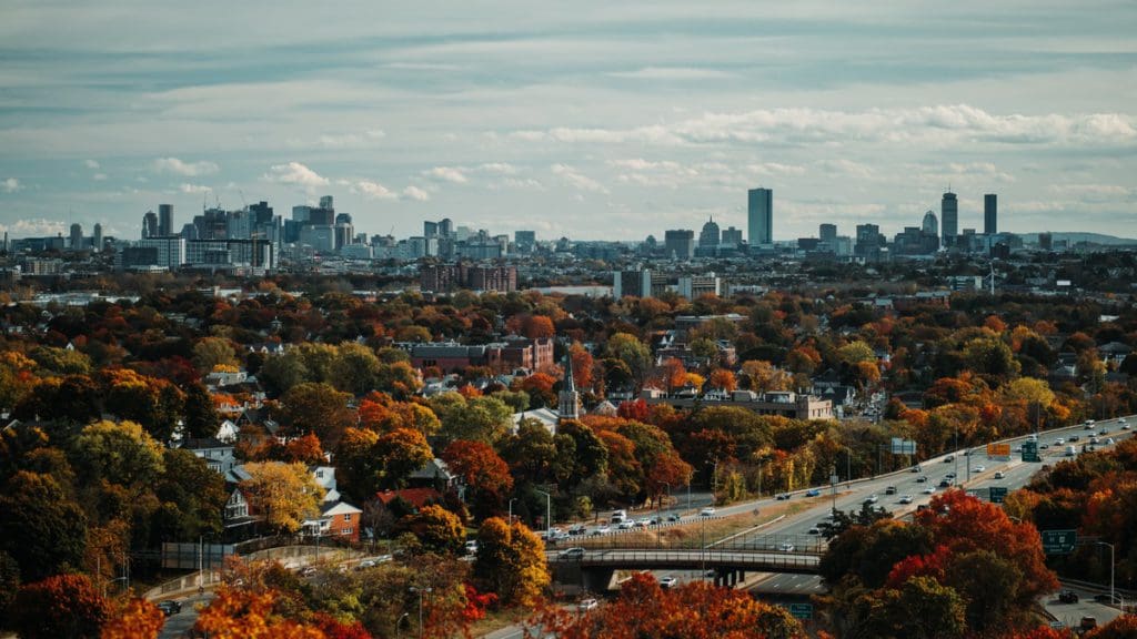 An aerial view of Boston, studded in colorful fall foliage.