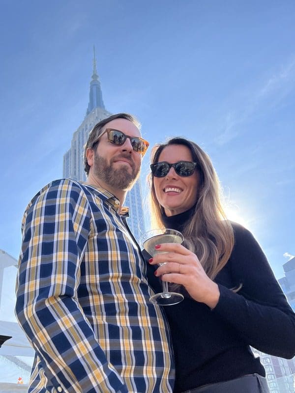 A couple stands together, while enjoying a beautiful day in NYC.