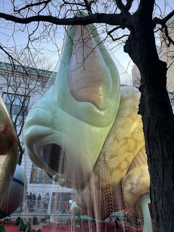 A Grogu parade balloon is under the nets at a pre-Marcy's Day Parade event.