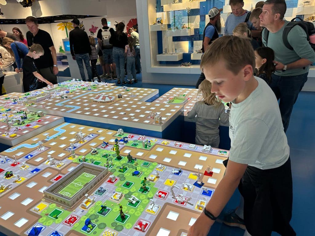 A young boy interacts with a LEGO display within the LEGO House in Denmark.