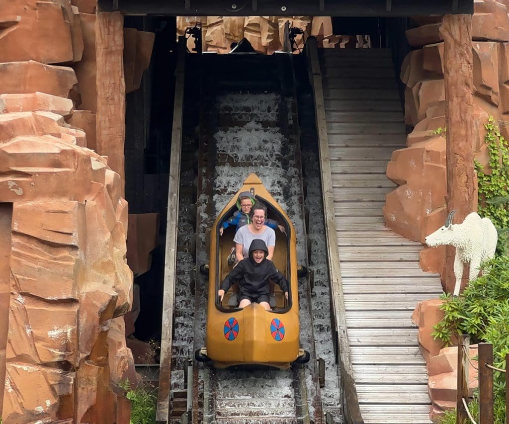 A mom and her two young sons shoot down a water ride at LEGOLAND® Billund Resort.