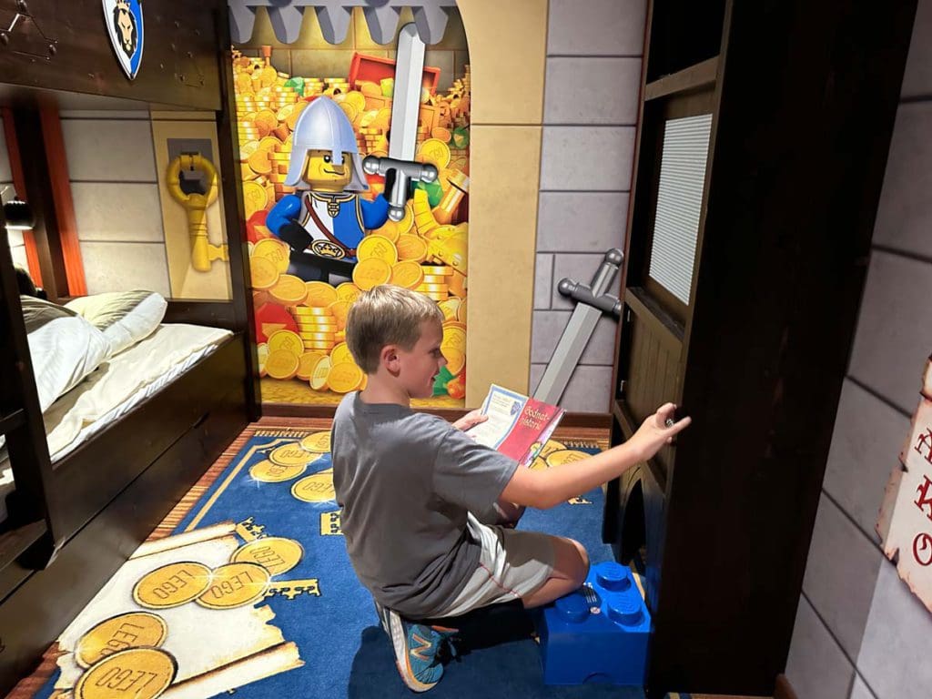 A young boy delights in exploring his knight-themed room at LEGO Castled Hotel in Denmark.