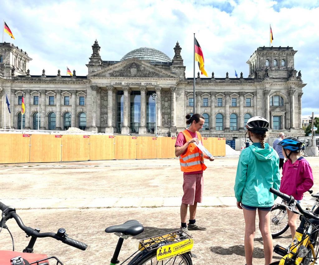 A guide provides information while on a bike tour of Berlin, a must on any Berlin itinerary with kids.