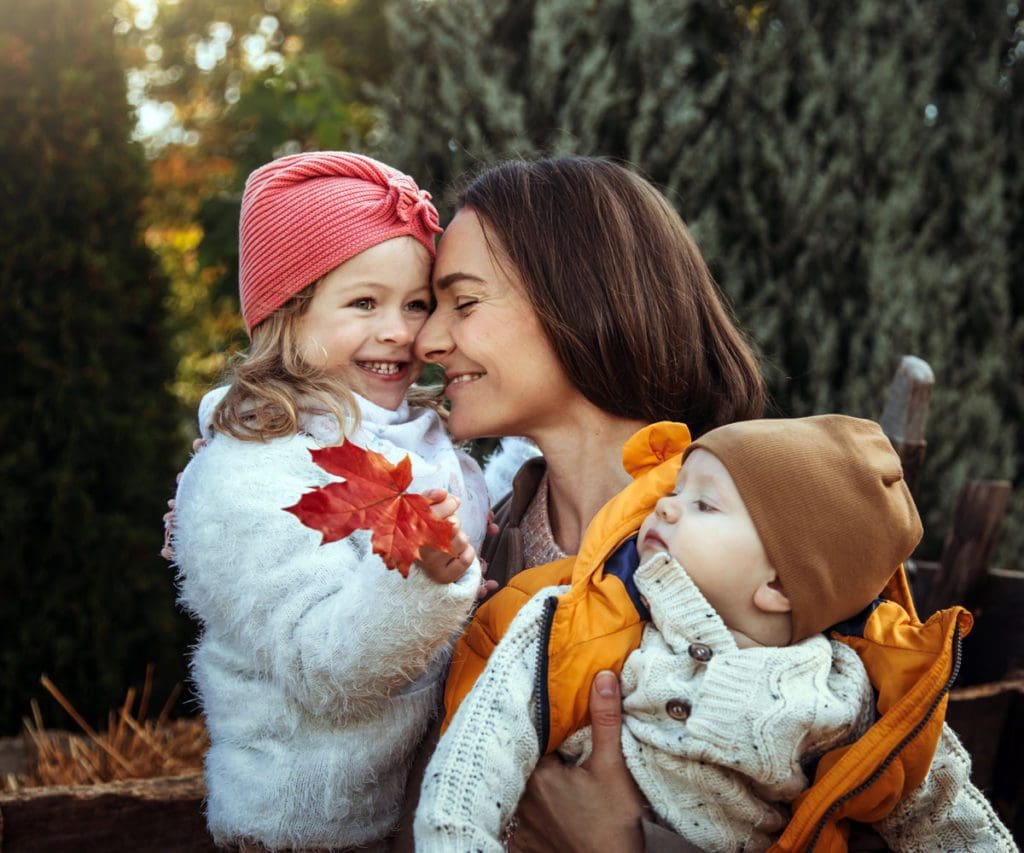 A mom and her two kids snuggle as they celebrate Thanksgiving together.