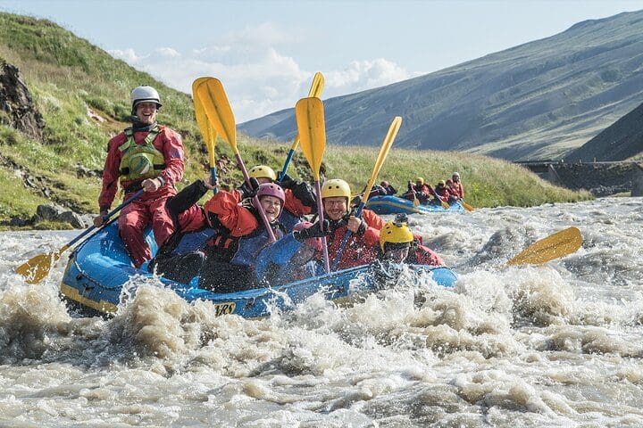 A raft full of people moves down a river on the Family Rafting Day Trip from Hafgrímsstaðir: Grade 2 White Water Rafting on the West Glacial River.