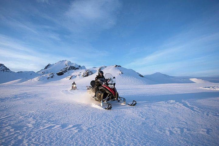 People snowmobile along a glacier, while on the Golden Circle & Glacier Snowmobiling Day Trip from Reykjavik.