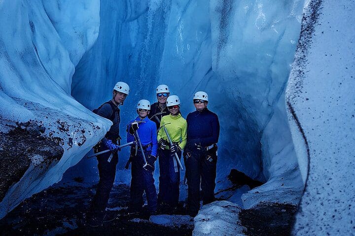 A family stands inside a glacier, while on the Half-Day Vatnajokull Glacier Small Group Tour from Skaftafell, one of the best Iceland tours with kids.