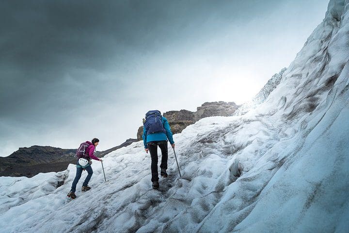 Two people hike along a glacier, while on the Half-Day Vatnajokull Glacier Small Group Tour from Skaftafell.