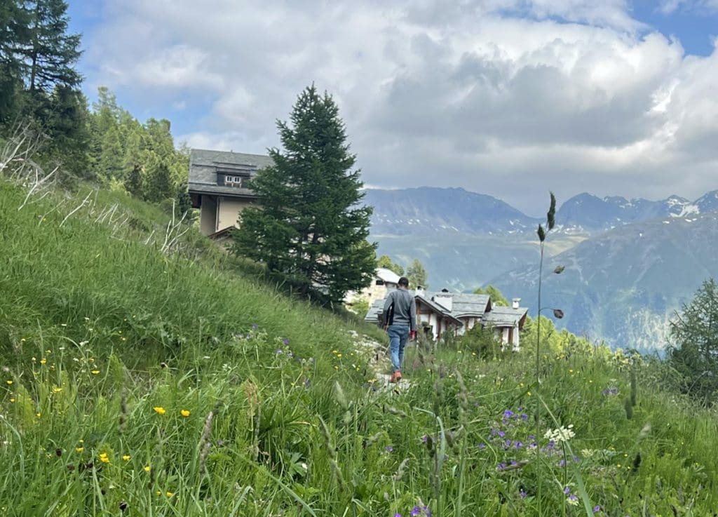 A young boy hikes a long a trail in the Swiss Alps, a must do activity on any St Moritz Itinerary with kids.