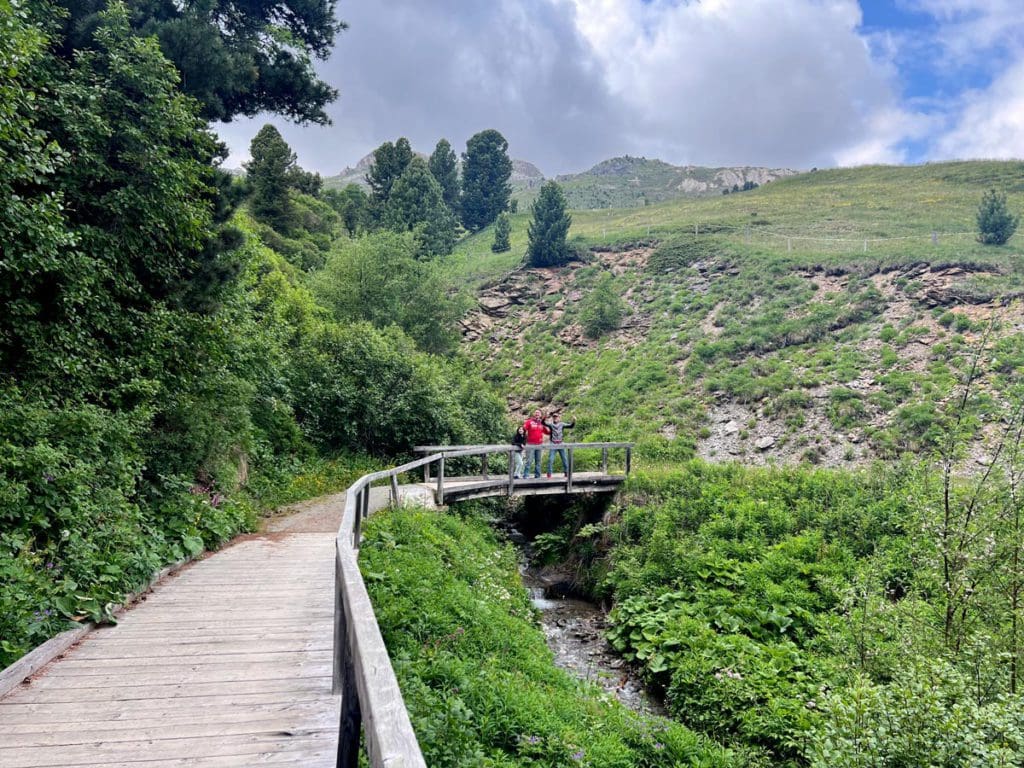 A family walks along a boardwalk, while hiking in the Swiss Alps near St. Moritz.