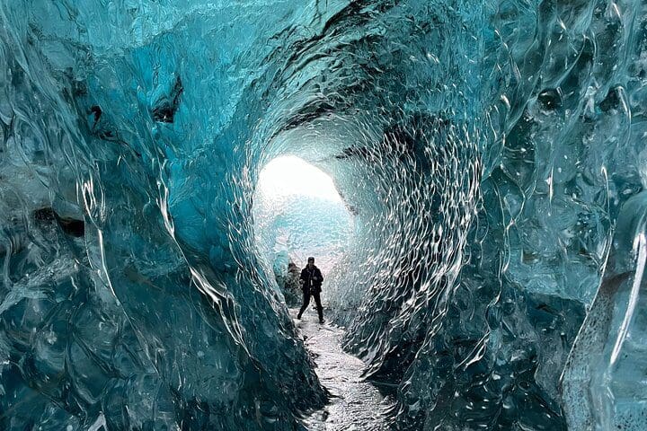 People stand inside a glacier, while on the Ice Exploration Tour from the Glacier Lagoon.