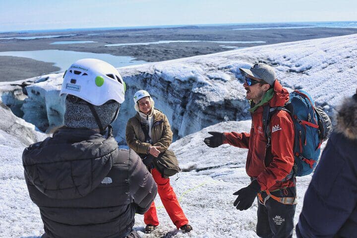 A tour guide leads a discussion atop a glacier on the Ice Exploration Tour from the Glacier Lagoon.
