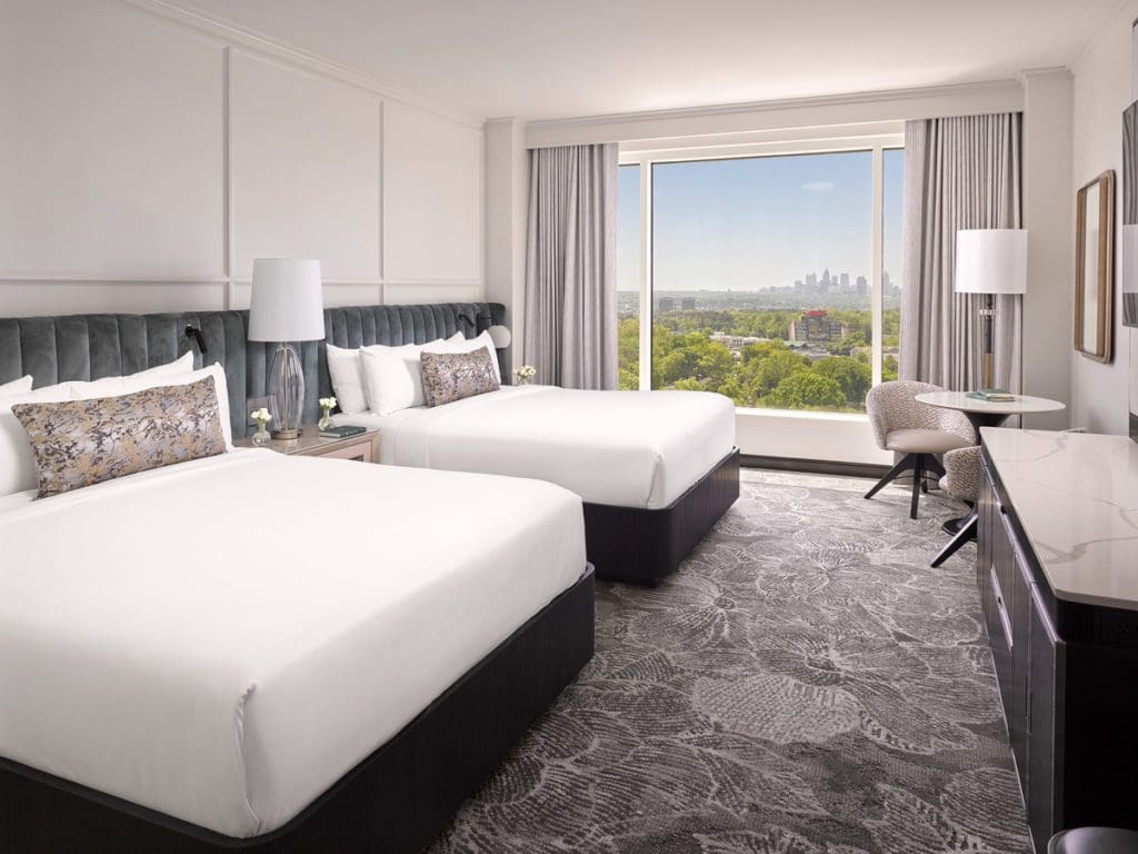 Inside a guest room at InterContinental Buckhead Atlanta with two Queen beds and a cit view.