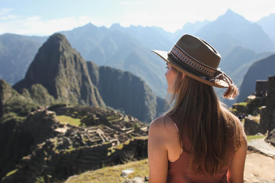 A young girl looks out onto Machu Picchu below.