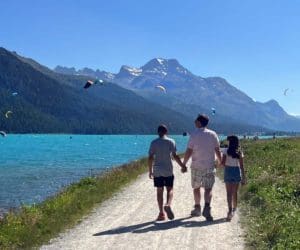 A dad and his two kids walk hand-in-hand along a path near Lake Silvapana.