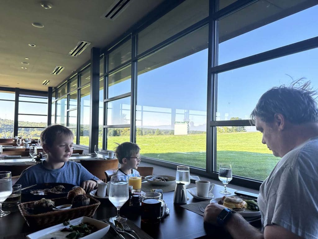 A dad and his two young kids eat breakfast at Nemacolin.