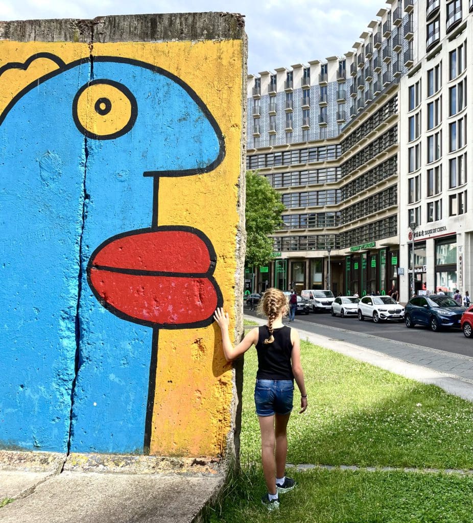 A young girl looks at a mural near the Spy Museum in Berlin.