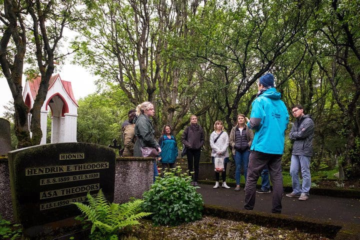 People explore a cemetery on a Reykjavik Folklore Walking Tour: Meet the Elves, Trolls & Ghosts of Iceland, one of the best Iceland tours with kids.